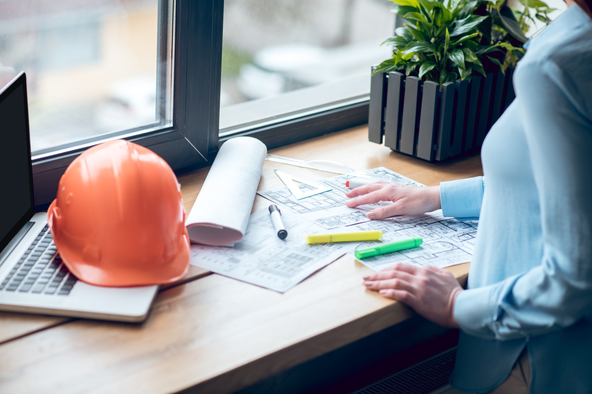 Womans hands near construction plan drawings