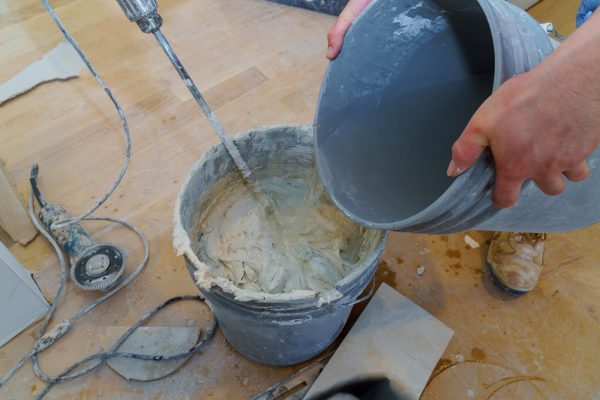 Cement mix using an electric drill tile adhesive in a bucket for tiling